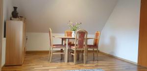 a dining room table and chairs with a vase of flowers on it at Ferienwohnung im Herzen von Thüringen in Blankenhain