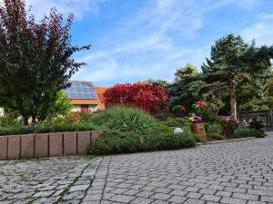 a garden with a house with a solar roof at Ferienwohnung im Herzen von Thüringen in Blankenhain