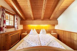 a large bed in a room with wooden ceilings at Hof am Schloss Apartement Lärche in Montechiaro