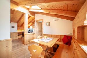 a dining room in a log cabin with a wooden table at Hof am Schloss Apartement Lärche in Montechiaro