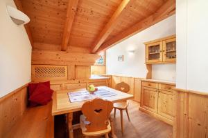 a kitchen with a wooden ceiling with a table and chairs at Hof am Schloss Apartement Lärche in Montechiaro