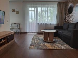 a living room with a couch and a table at Trumpalaikė nuoma centre in Šiauliai