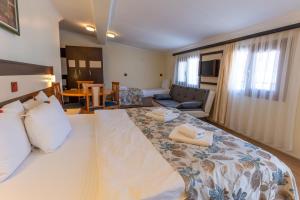 a bedroom with a large bed and a living room at Hotel Karacam in Foca