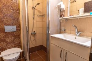 a bathroom with a shower and a sink and a toilet at Hotel Karacam in Foça