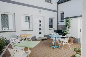 a patio with tables and chairs and a couch at Haus Mörbisch - Großes Familienapartment mit ruhigem Innenhof am Neusiedler See in Mörbisch am See
