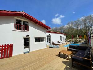 a house with a wooden deck with a swimming pool at Villa avec Piscine à 5 minutes de l’océan in Bidart