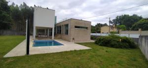 a house with a swimming pool in a yard at La casa de Cristal in Goyán