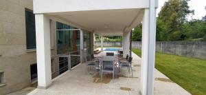 a patio of a house with a table and chairs at La casa de Cristal in Goyán