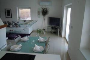 a living room with a table and chairs and a television at Luxury apartment fireplace + sauna in Stará Paka