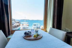 a table with a bowl of fruit and a view of a boat at Hotel Karacam in Foça