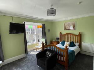 Bryncelyn Guesthouse في لانْوُرتيد ويلز: غرفة نوم بسرير وكرسي