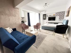 een woonkamer met een blauwe bank en een bed bij SOLID BARRELS LAKE VIEW STUDIOS in Mamaia