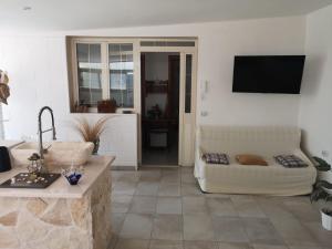 a living room with a couch and a flat screen tv at Villa Rhaele in Taranto