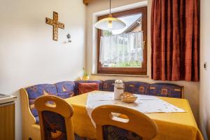 een eettafel met een geel tafelkleed en een kruis bij Rotsteinhof Apartement Sonnenschein in Verano