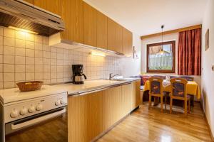 een keuken met een fornuis en een tafel met stoelen bij Rotsteinhof Apartement Sonnenschein in Verano