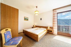 een slaapkamer met een bed en een groot raam bij Rotsteinhof Apartement Sonnenschein in Verano