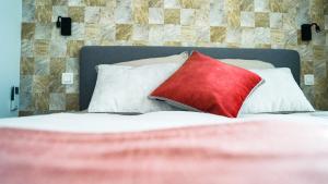 uma almofada vermelha sentada em cima de uma cama em Le Paradis d'Henri em Hannut
