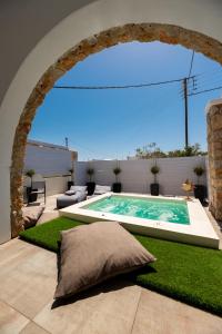 a swimming pool in the middle of a yard with an arch at Kasteli Suites in Perivolos