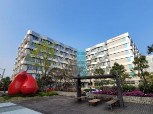 a red apple statue and benches in a park at Chungchoho Best Hotel in Sokcho