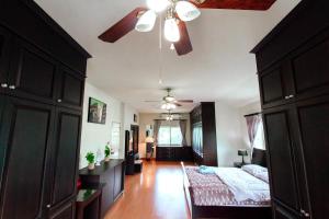 - une chambre avec un lit et un ventilateur de plafond dans l'établissement PRIVATE RESIDENCE HOSTED by Sasithorn, à Nong Prue