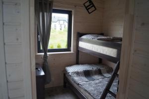 a room with two bunk beds and a window at SŁONECZNE DOMKI in Gąski