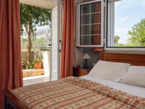 a bedroom with a bed and a large window at Villa Maria Laganas in Laganas