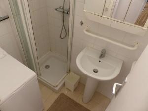 ein weißes Bad mit einer Dusche und einem Waschbecken in der Unterkunft Appartement Le Lavandou, 2 pièces, 4 personnes - FR-1-308-61 in Le Lavandou