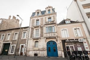 un vieux bâtiment avec une porte bleue dans une rue dans l'établissement L'Atlantide Apt 85m2 3 chambres - Appart Hotel Poitiers, à Poitiers