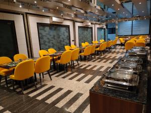 una sala da pranzo con sedie e tavoli gialli di Sapphero Resorts a Shirdi Altre 60 foto
