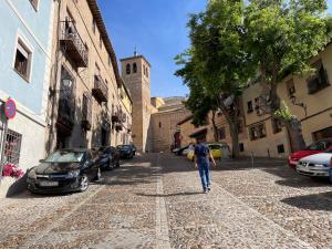 a man walking down a cobblestone street at Acogedor apartamento en el casco histórico in Toledo