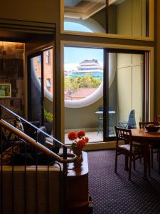 Zimmer mit einem großen Fenster und einem Tisch mit Blumen in der Unterkunft Bell Hill Apartments in Dunedin