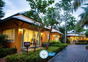 a resort with a sign in front of a building at Baan Amphawa Resort & Spa - SHA Certified in Amphawa