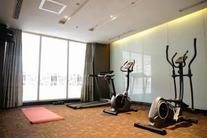 a gym with exercise bikes and a large window at Empress Hotel Makassar City Center by LIFE in Makassar