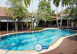 a swimming pool in front of a hotel at Baan Amphawa Resort & Spa - SHA Certified in Amphawa