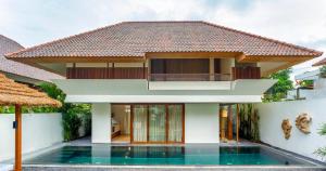 a house with a swimming pool in front of it at Bisma Eight Villas in Ubud