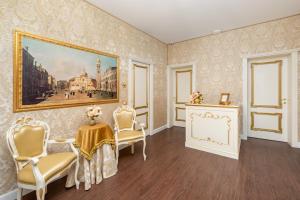 una habitación con una pintura, sillas y una mesa en La Veneziana Boutique Rooms 2 en Venecia