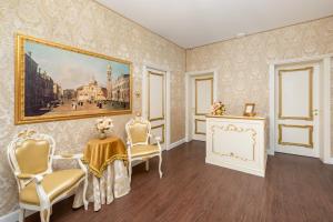 una stanza con un dipinto, sedie e un tavolo di La Veneziana Boutique Rooms 2 a Venezia 1 altra foto