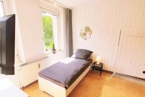 um pequeno quarto com uma cama e uma janela em 2 room apartment in Velbert em Velbert