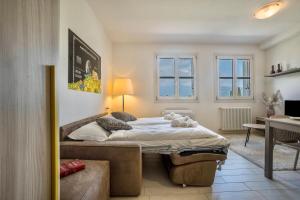 una camera con letto, scrivania e finestre di Appartamento Madeleine a Toscolano Maderno