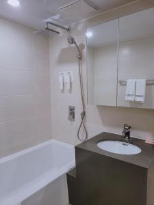 a white bathroom with a sink and a shower at Chungchoho Best Hotel in Sokcho