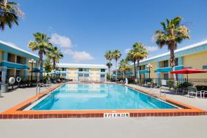 a swimming pool at a resort with palm trees at Garnet Inn & Suites, Orlando in Orlando