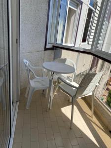 een patio met een tafel en stoelen op een balkon bij MAR DE BAIONA in Baiona