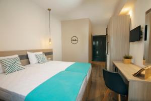 a hotel room with a bed and a desk and a television at Akti Liakada Hotel in Gerakini