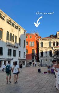 un grupo de personas caminando por una calle de la ciudad en La Veneziana Boutique Rooms 2, en Venecia