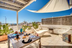 un patio con tavolo e sedie sul tetto di Il Nido - Le Case di Valentina a Gallipoli