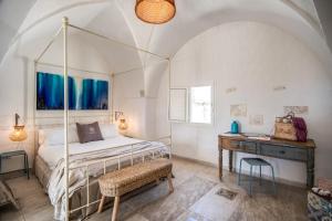 una camera da letto con un letto a baldacchino e un tavolo di Il Nido - Le Case di Valentina a Gallipoli
