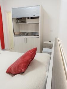 a red pillow sitting on top of a bed at Be Inn in Salerno