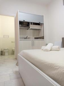 a white bedroom with a bed and a sink at Be Inn in Salerno