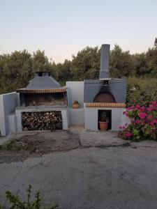 a building with an outdoor oven with flowers at Amalthia in Sitia