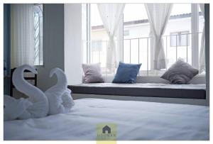 a bedroom with a bed with swans in front of a window at Hooman Hostel in Chiang Mai